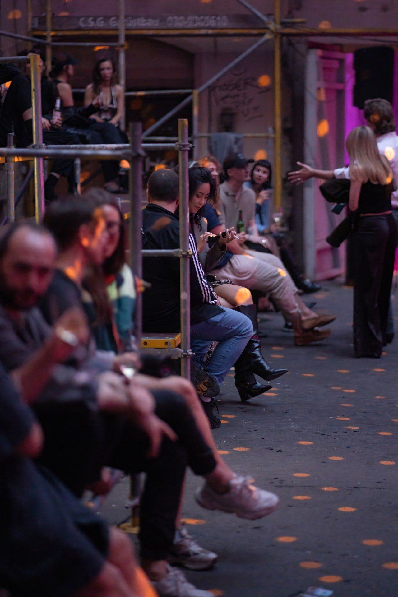 The real bar counter in service during an ARTFETE night — staff, backlit drinks, guests in violet light